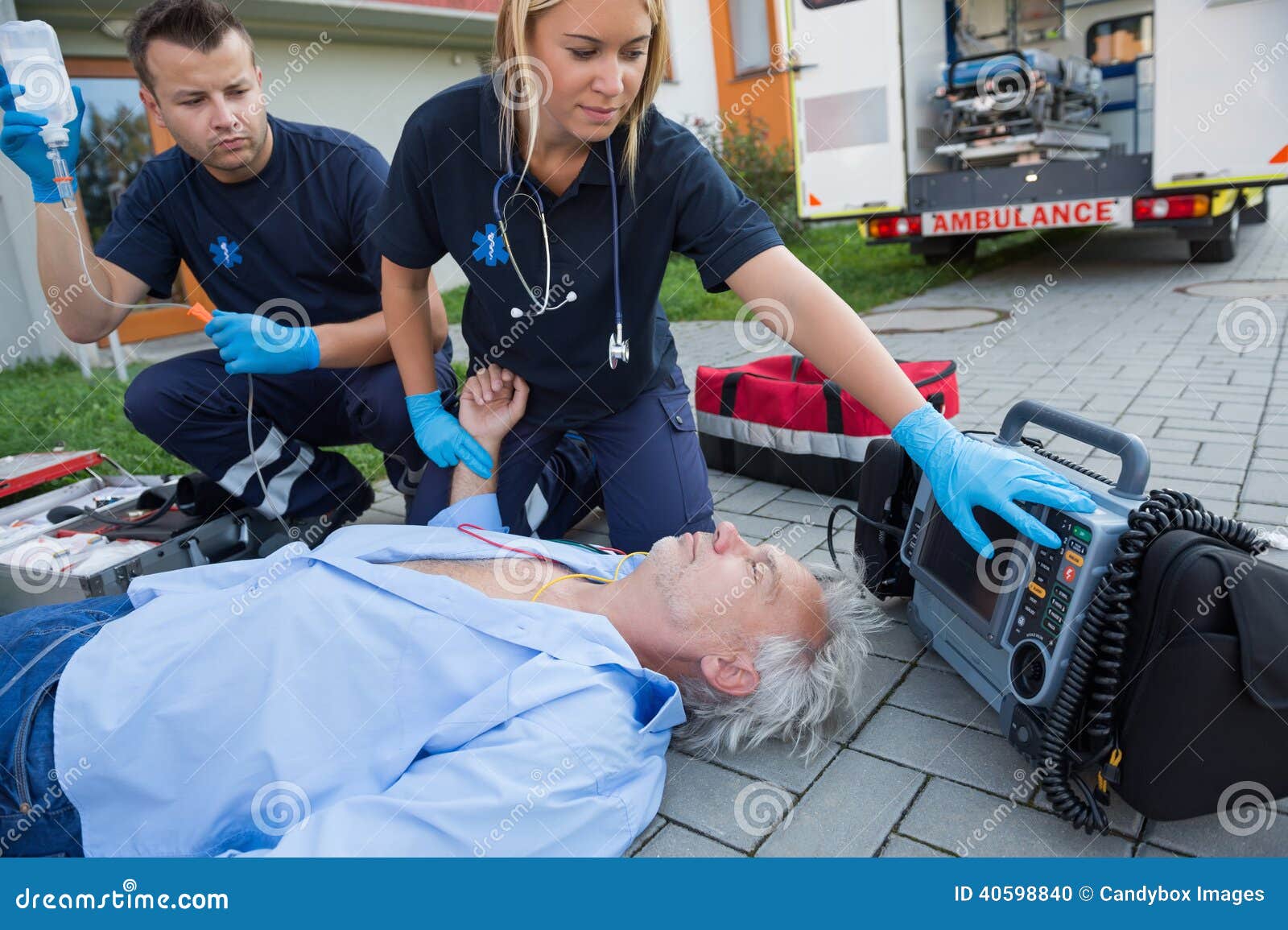 paramedics checking pulse of unconscious man