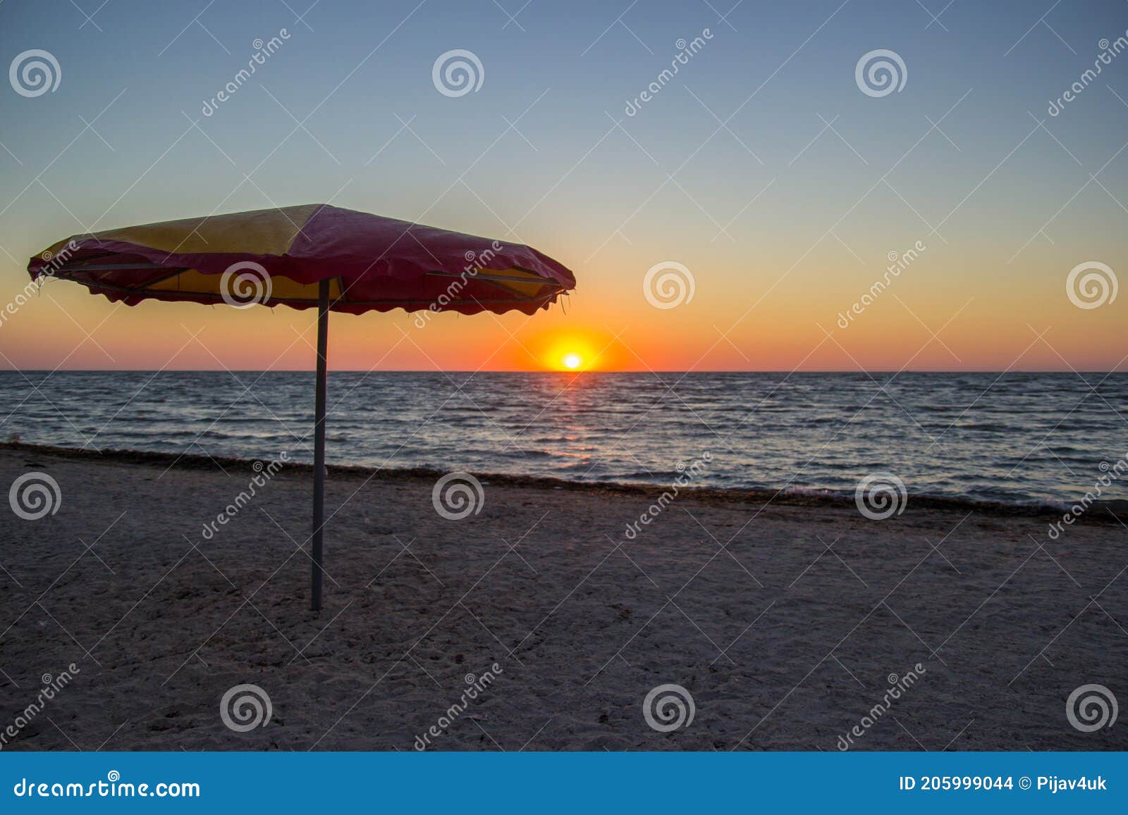 Parasol on Seaside in Sunrise with Calm Ocean Waves Stock Photo - Image ...