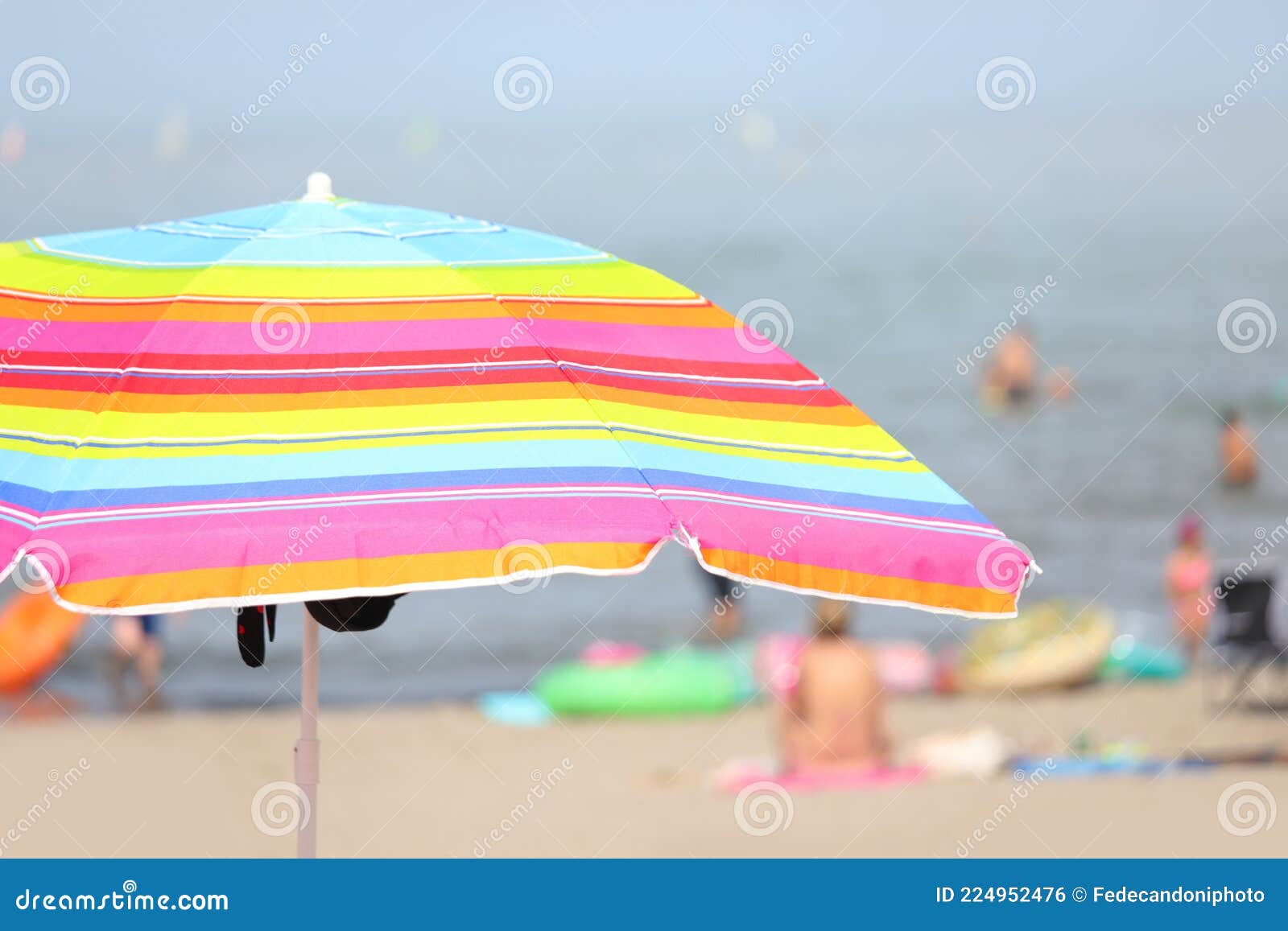 Parasol Umbrella on the Beach with Swimmers Having Fun during Th Stock ...