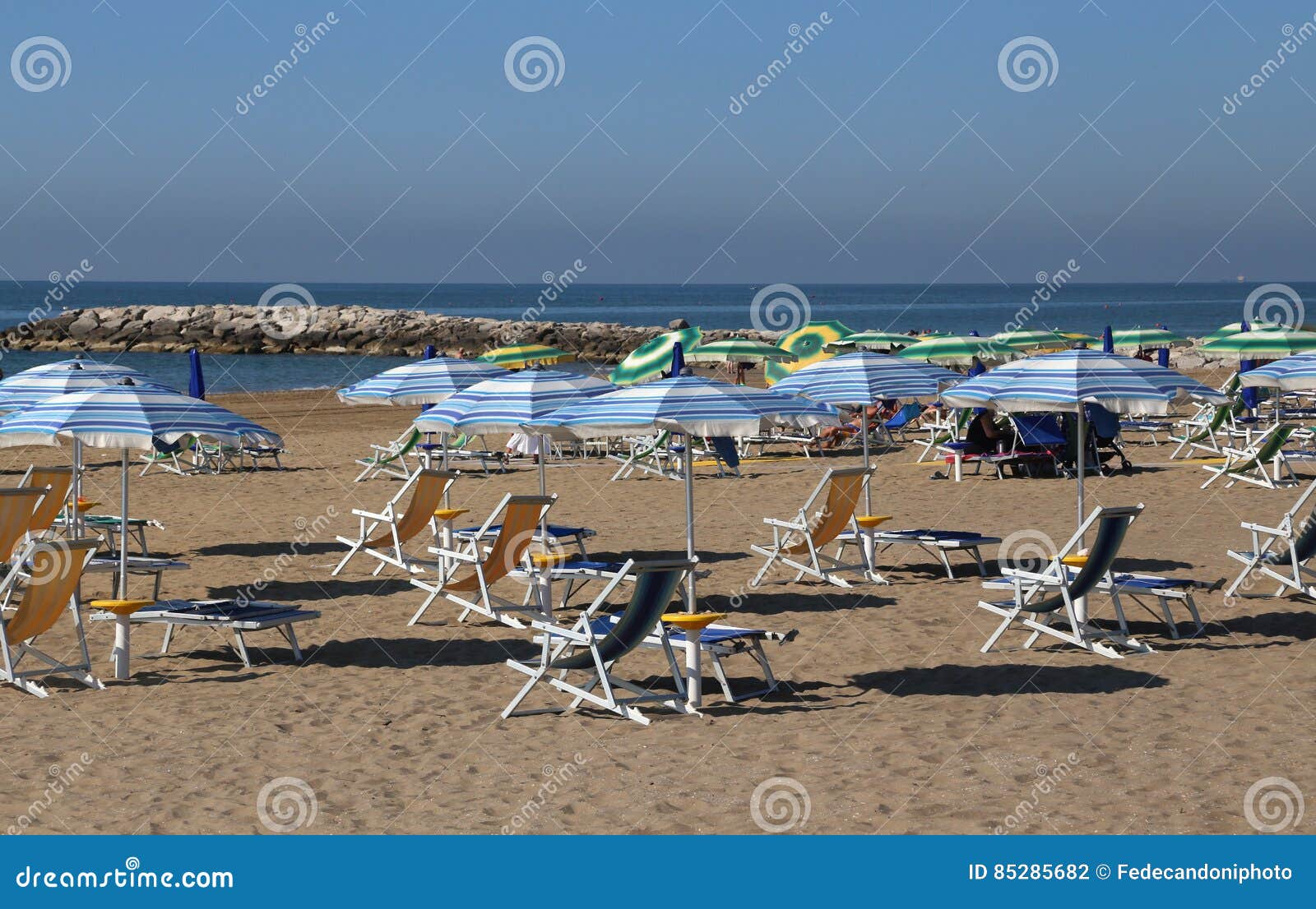 Parasols and Deck Chairs in the Sundrenched Beach in Summer Stock