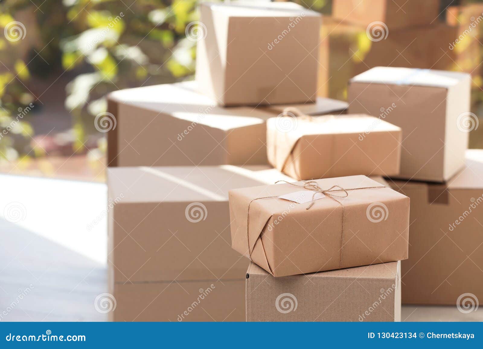 parcel with tag and blurred stacked boxes on background