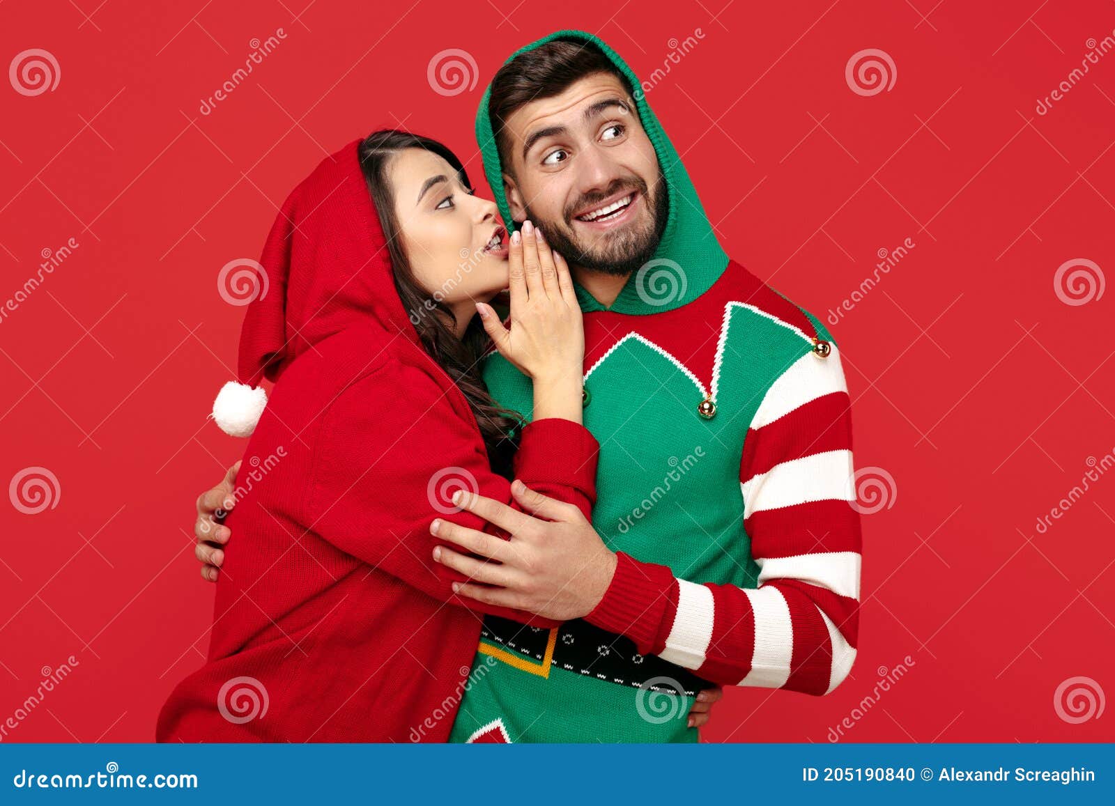 Pareja Atractiva Vestida De Navidad Chistosos Suéteres Sobre Fondo Rojo.  Mujer Susurrando En El Oído Del Hombre. Foto de archivo - Imagen de  vacaciones, santa: 205190840