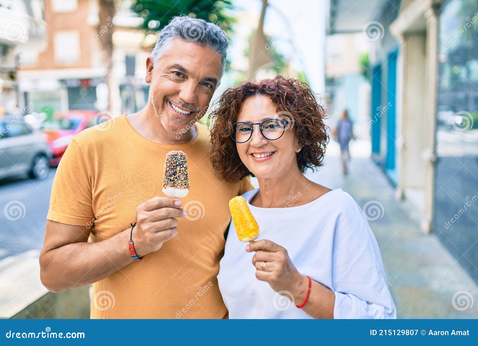 Pareja De Edad Media Sonriendo Feliz Comiendo Helado En Calle De La Ciudad Imagen de archivo - Imagen de hombre, coma: 215129807 Pareja De Edad Media Sonriendo Feliz Comiendo Helado En Calle De La Ciudad Imagen de archivo - Imagen de hombre, coma: 215129807