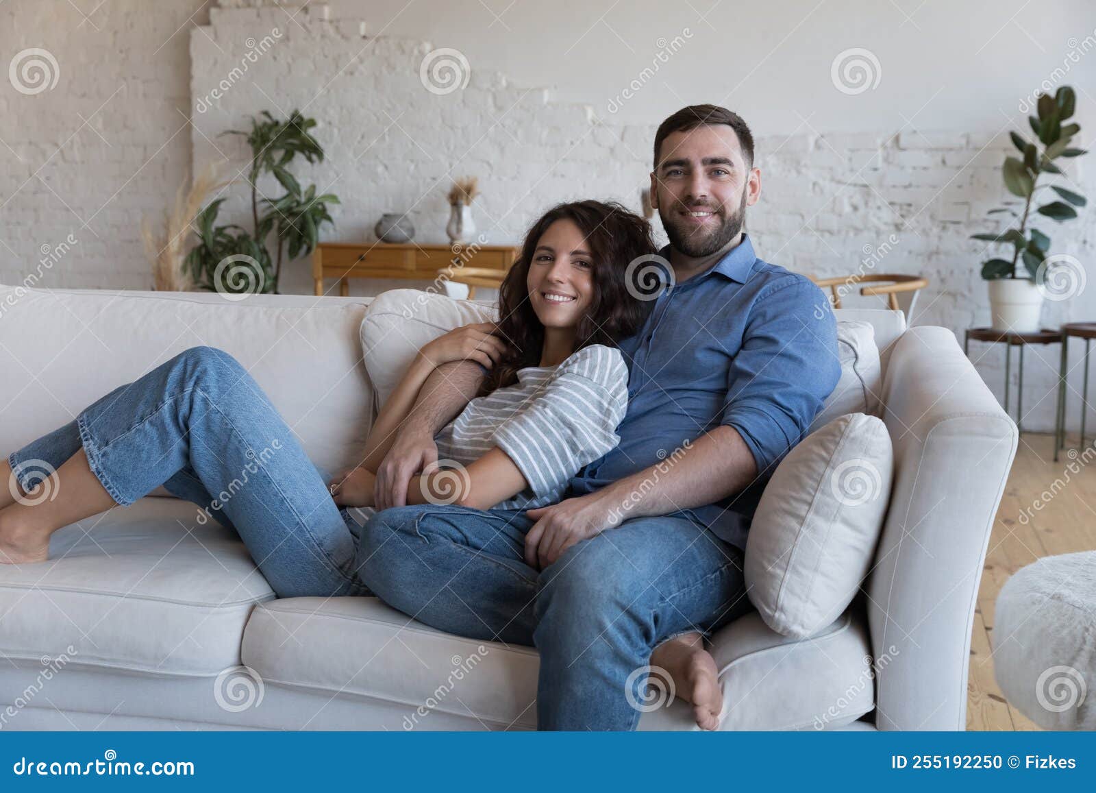 Pareja Multiétnica Relajándose En Una Cómoda Sonrisa En El Sofá Posando Para  La Cámara Foto de archivo - Imagen de feliz, casado: 255192250