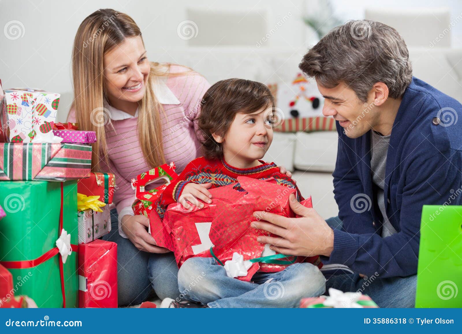 Parents Avec Le Cadeau De Noël D'ouverture De Fils Photo stock - Image du  soirée, enfants: 35886318