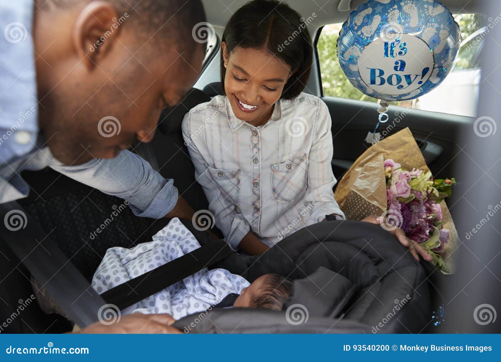 parents bringing newborn baby home in car