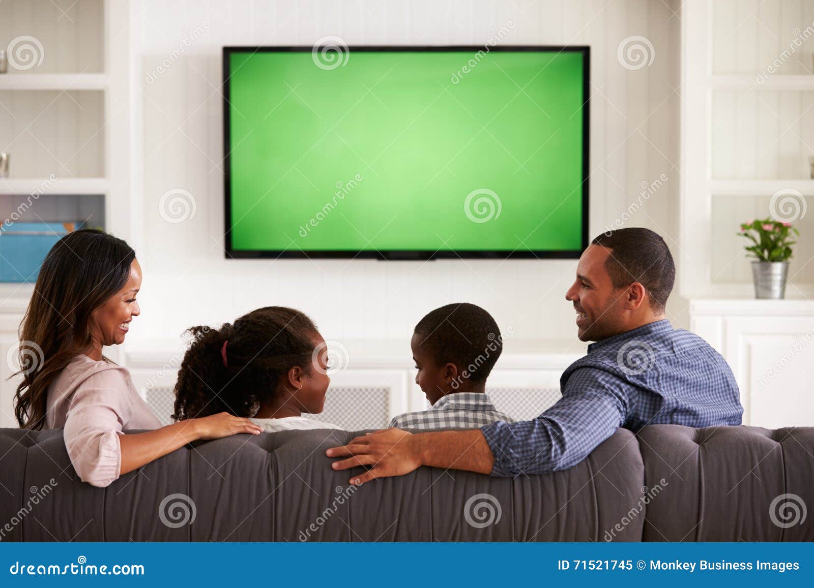 Parents and Children Watching TV, Looking at Each Other Stock Image