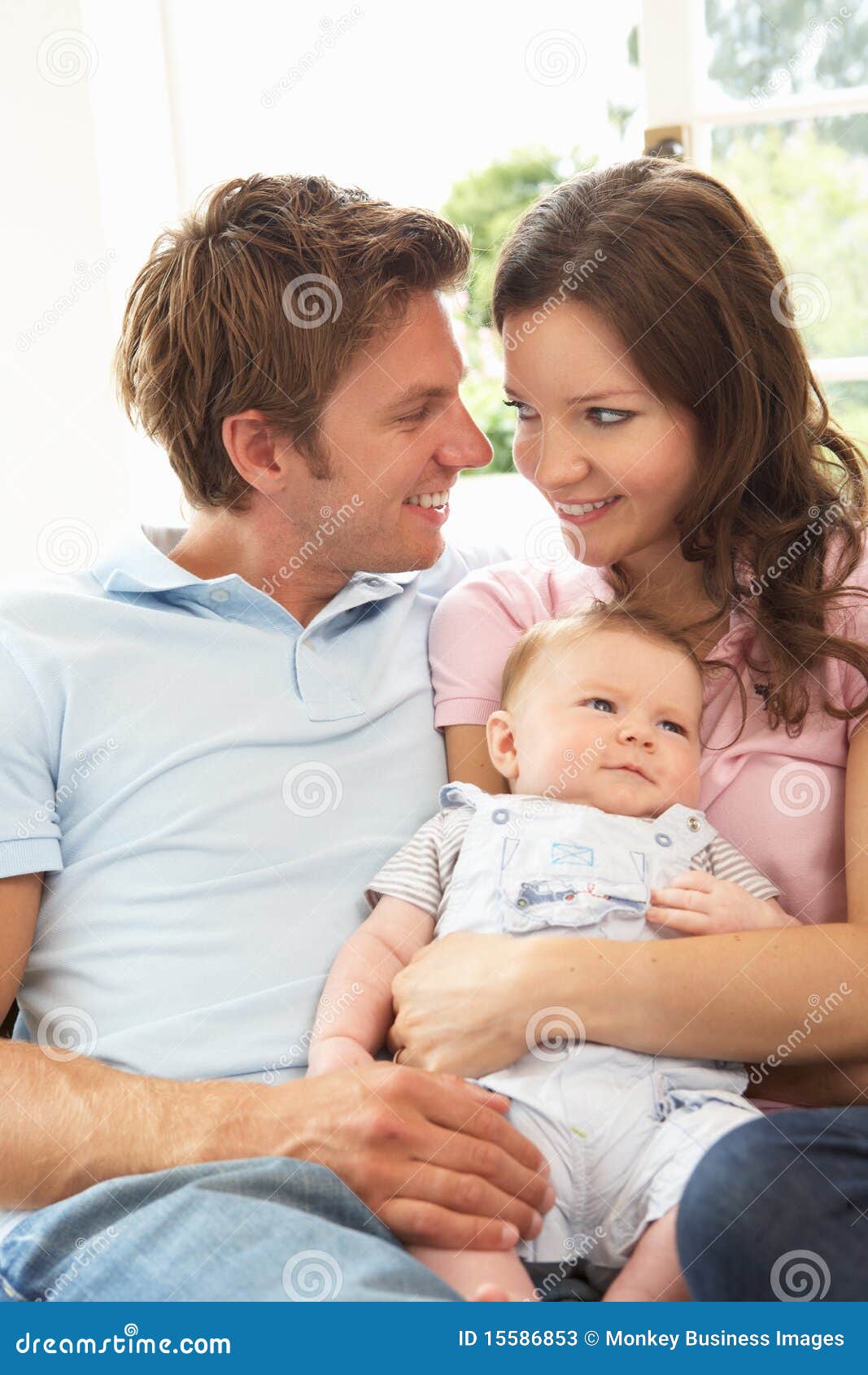 parents cuddling newborn baby boy at home