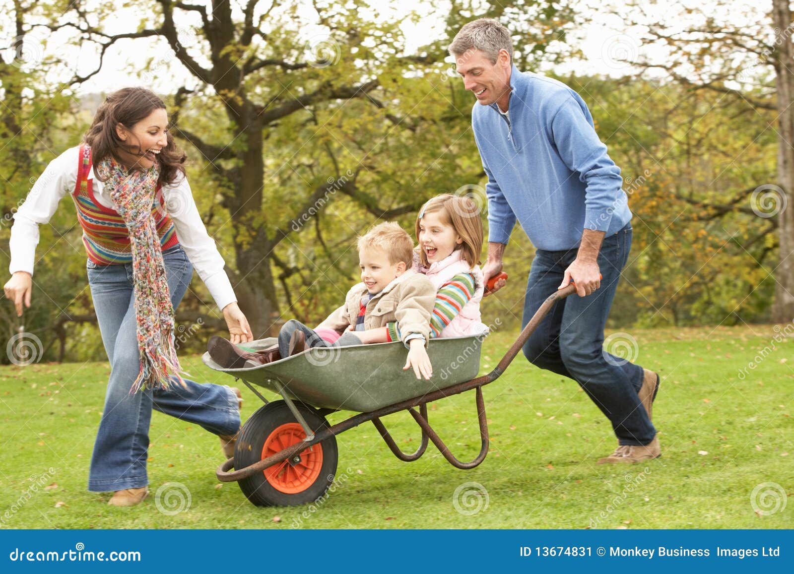 Parents Giving Children Ride in Wheelbarrow Stock Image Image of