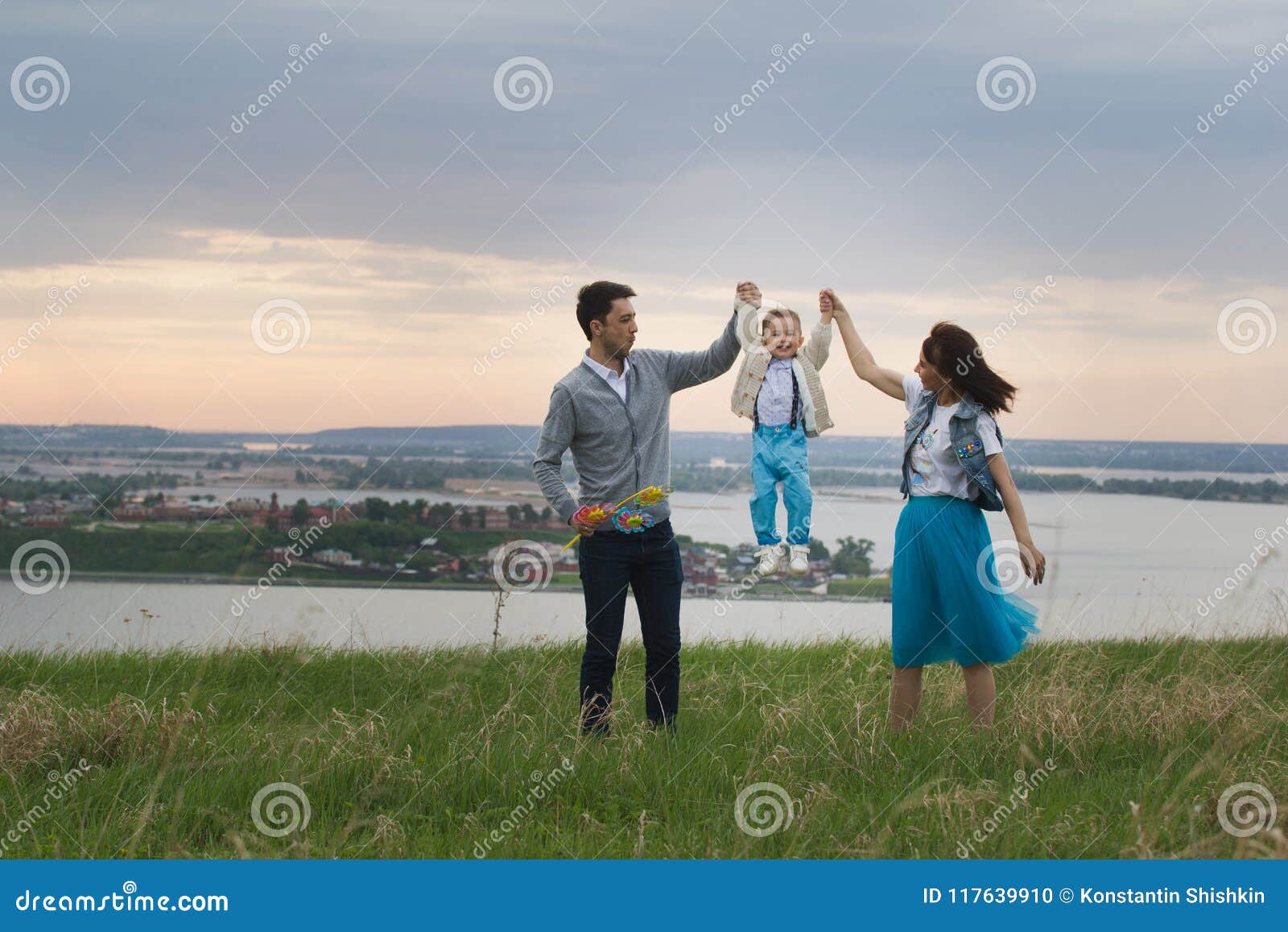 Parents Hold Their Son`s Hands And Raise, The Baby Jumps ...