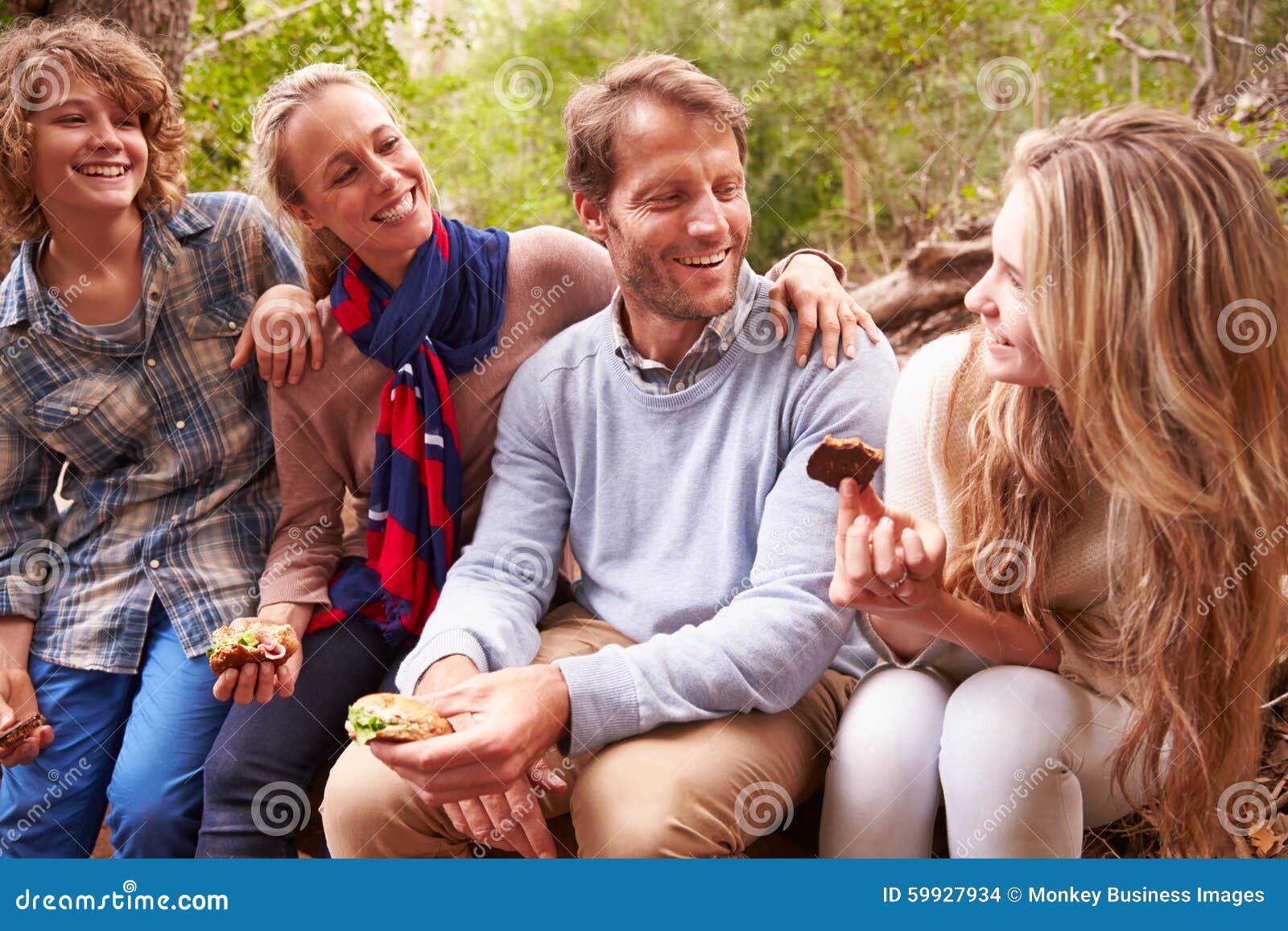 parents and teenage kids eating outdoors in a forest