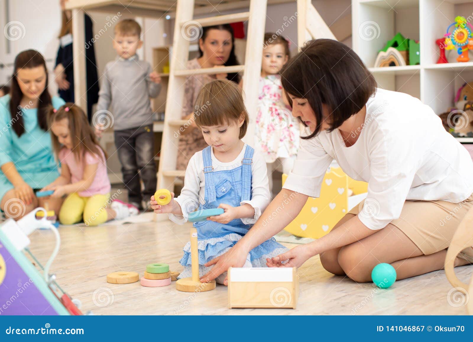 parents with children playing in playroom in daycare