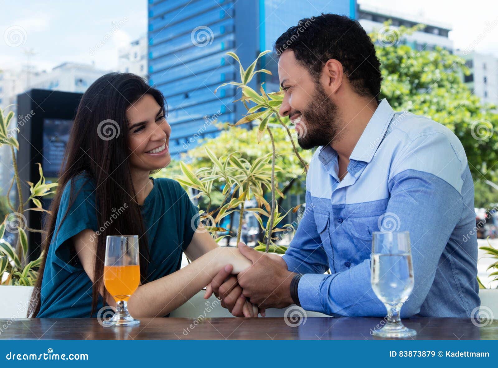 Pares do amor que guardam as mãos em um restaurante. Ame os pares que mantêm as mãos em um restaurante exteriores no verão
