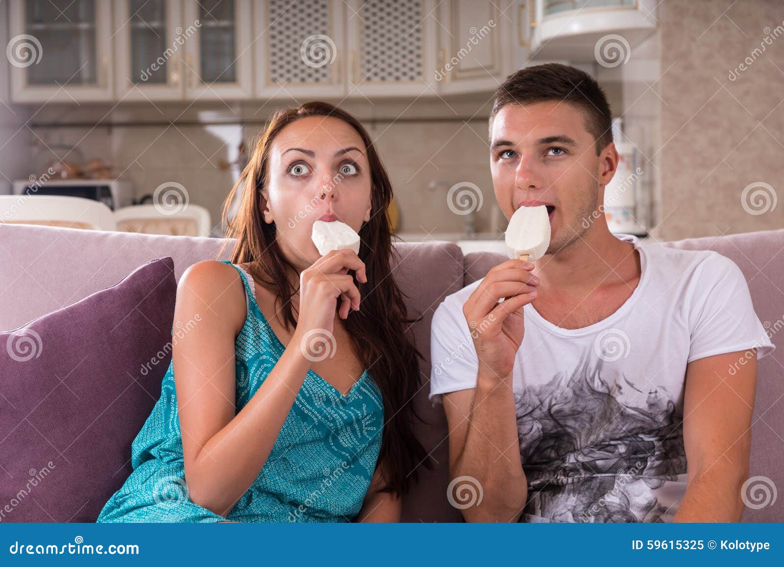 Есть мороженое ночью. Молодая пара ест мороженое. На диване с мороженым. Девушка с мороженым на диване. Мороженое перед телевизором.
