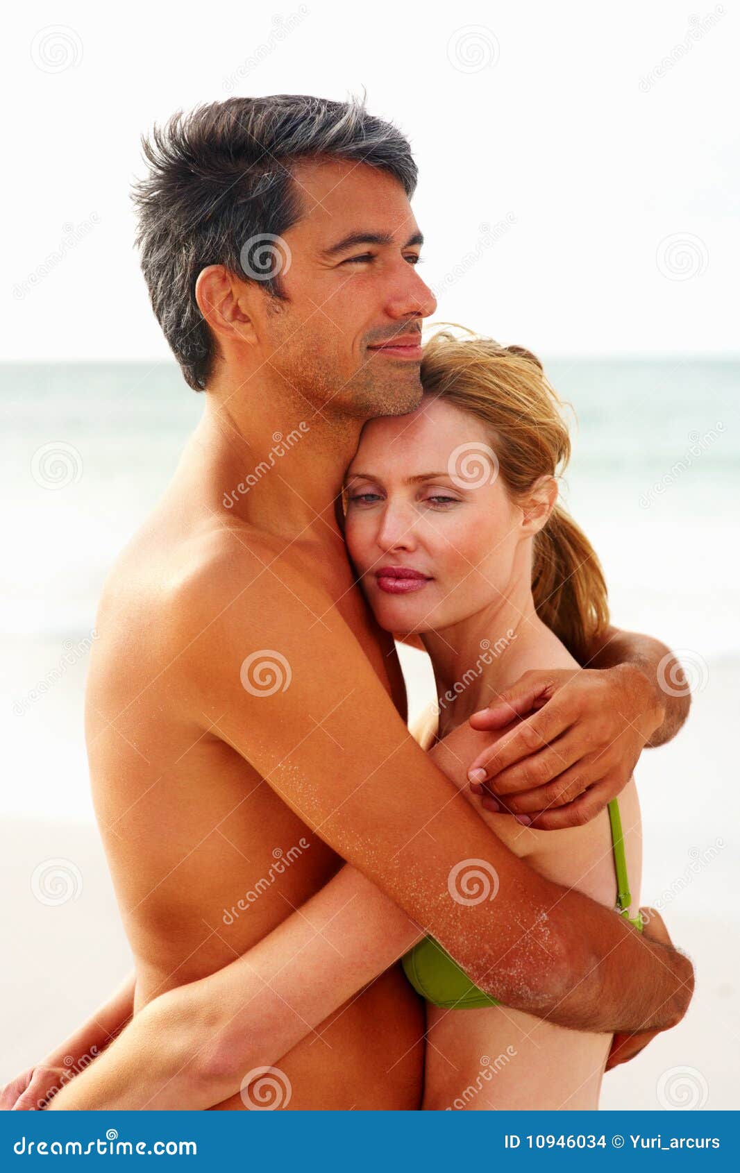 Pares que se abrazan y romancing en la playa. Pares felices que se abrazan y romancing en la orilla de mar