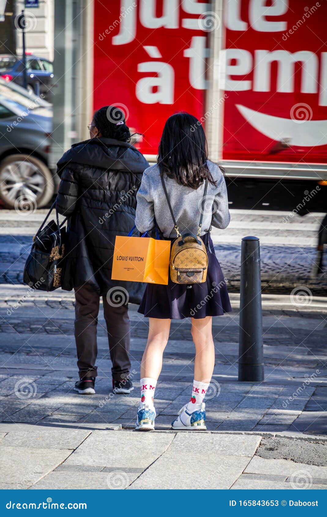 Visitors take photos of a suitcase on display during the Louis