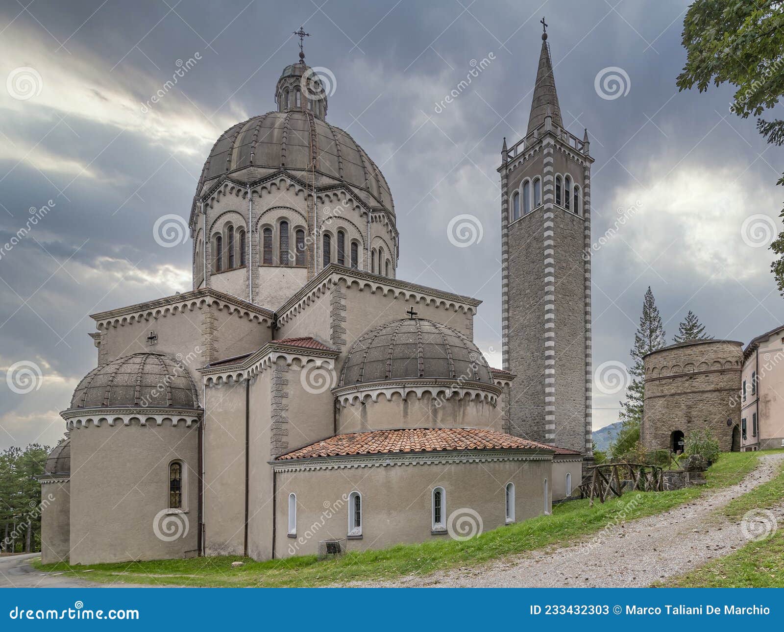 parish church of san mamante and delubro tower, lizzano in belvedere, italy, under a dramatic sky