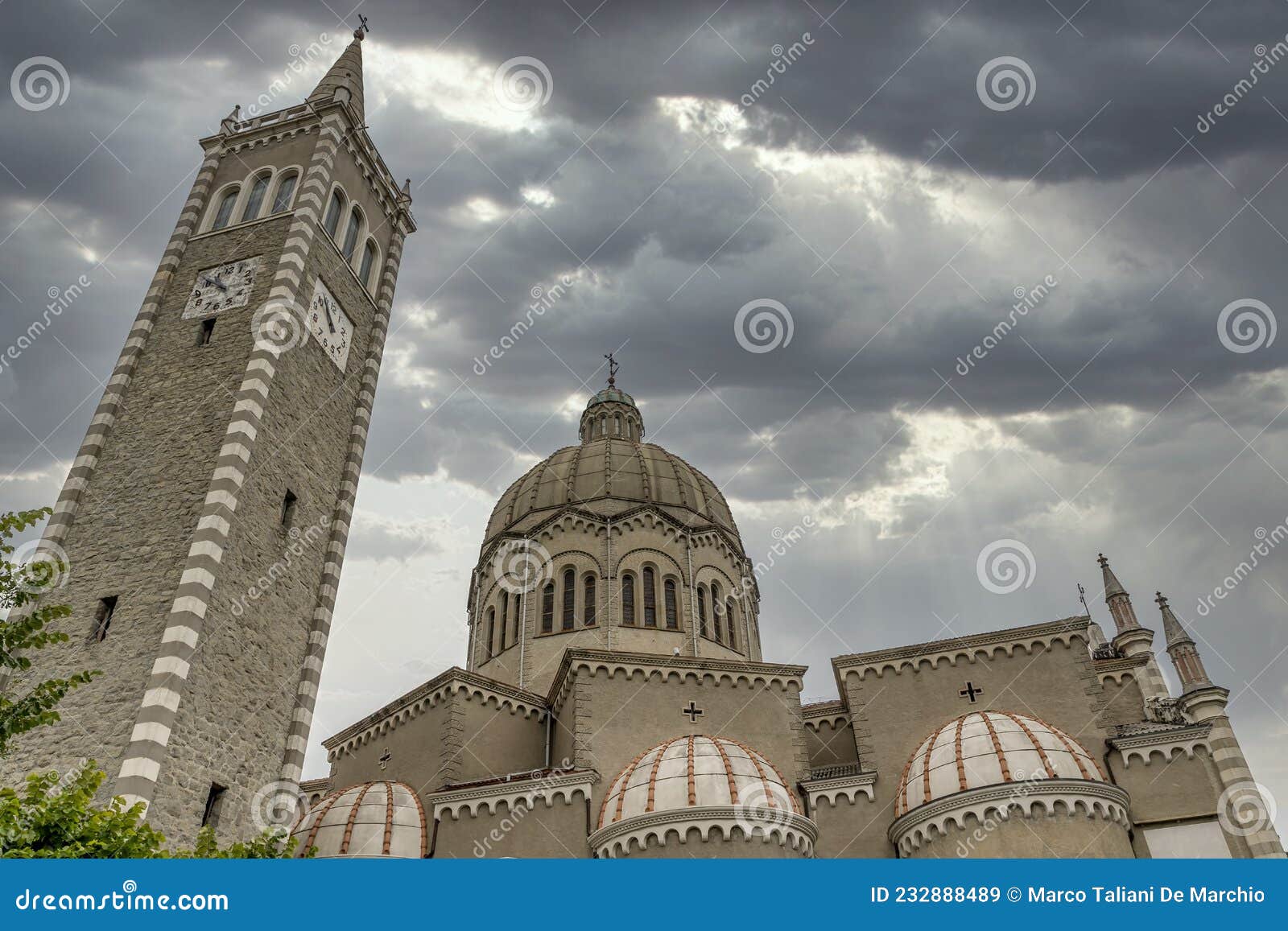 the parish church of san mamante, lizzano in belvedere, italy, under a dramatic sky