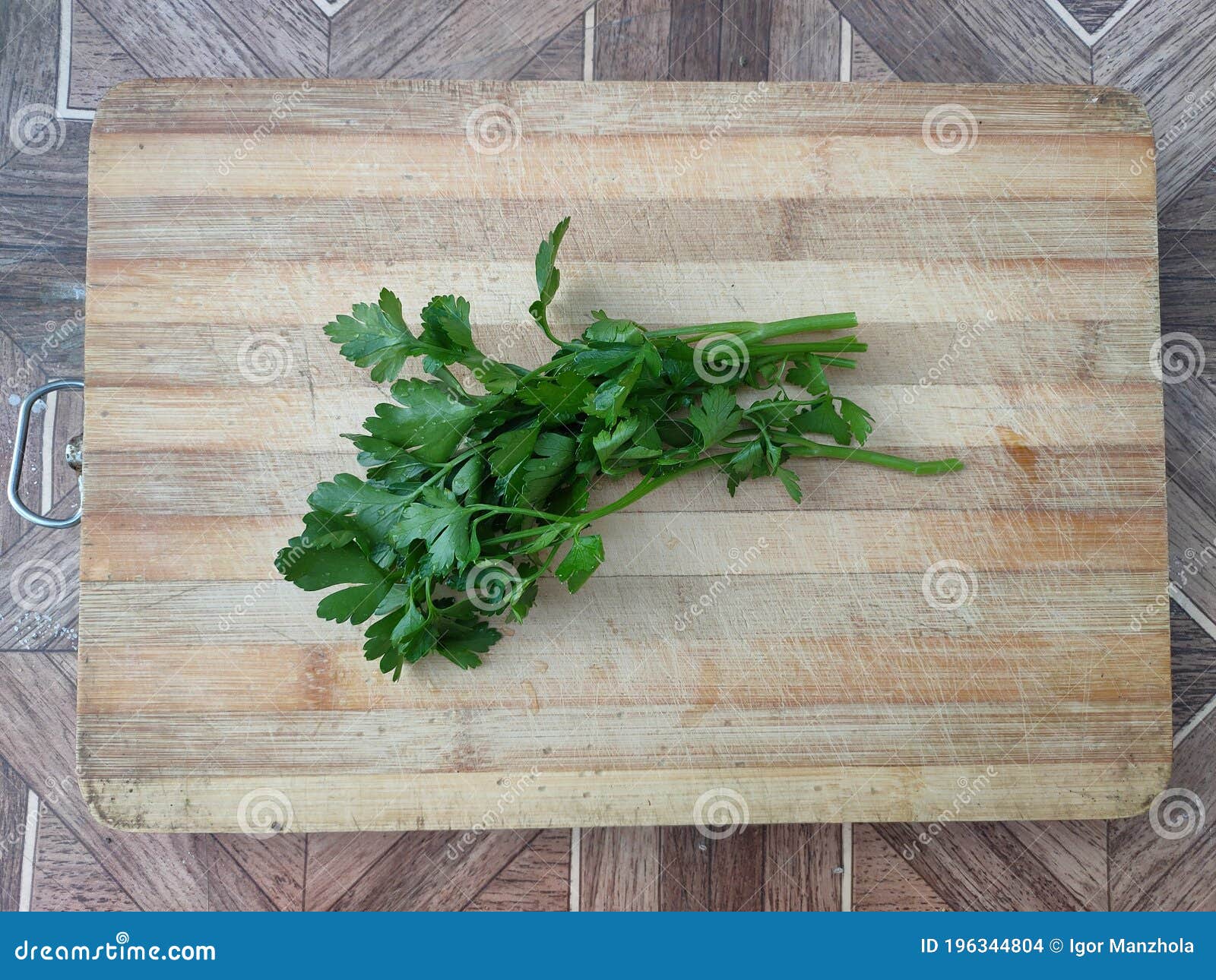 parsley on a wooden surface. fresh parsley on a cutting board. greens for making salad, soup, sauce, marinade, mayonnaise, fish.