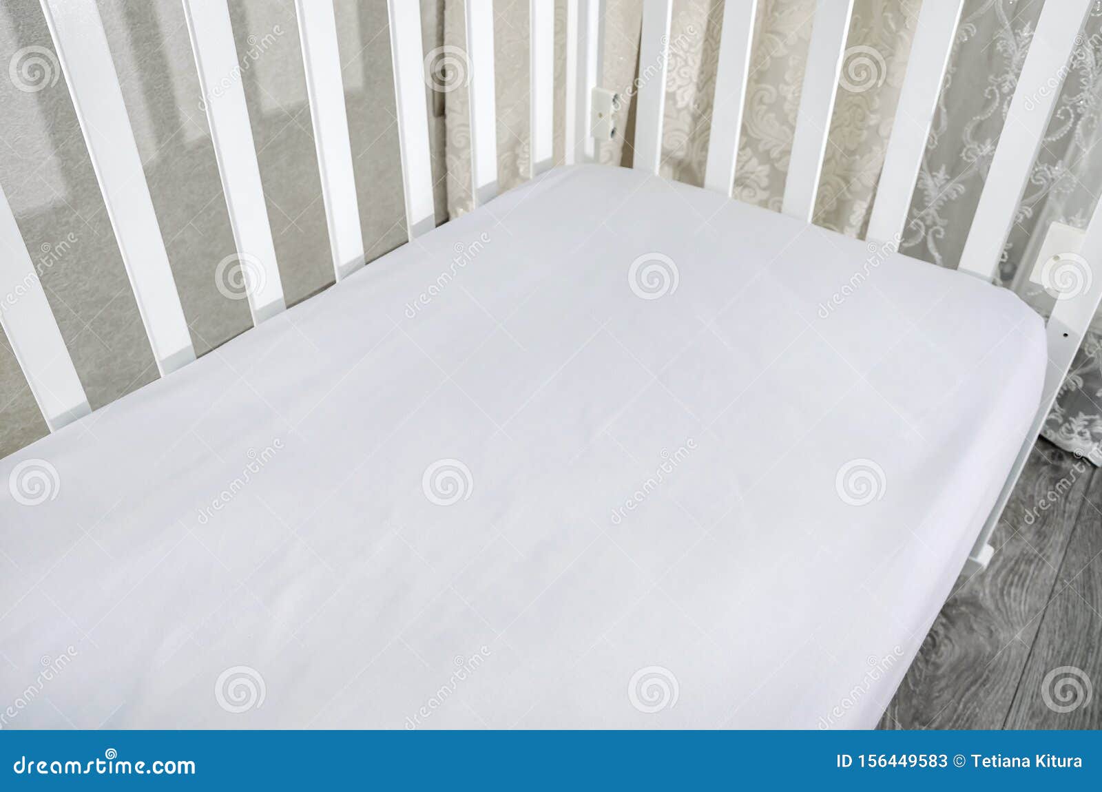Part of Baby Cot, Close Up. Mattress and Sheets in White Crib. Stock