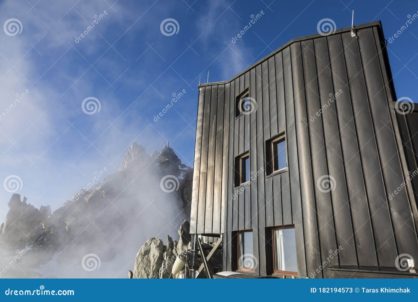 part cosmique refuge and view of aiguille du midi in the fog and clouds in the french alps, chamonix mont-blanc, france