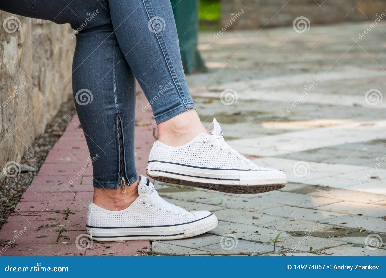 Part of the Legs of a Young Girl. Jeans and Sneakers Stock Image ...