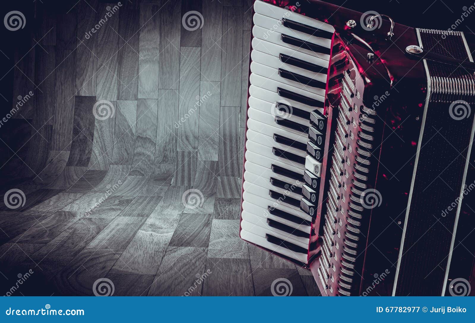 part pink accordion on wooden grey background. write text