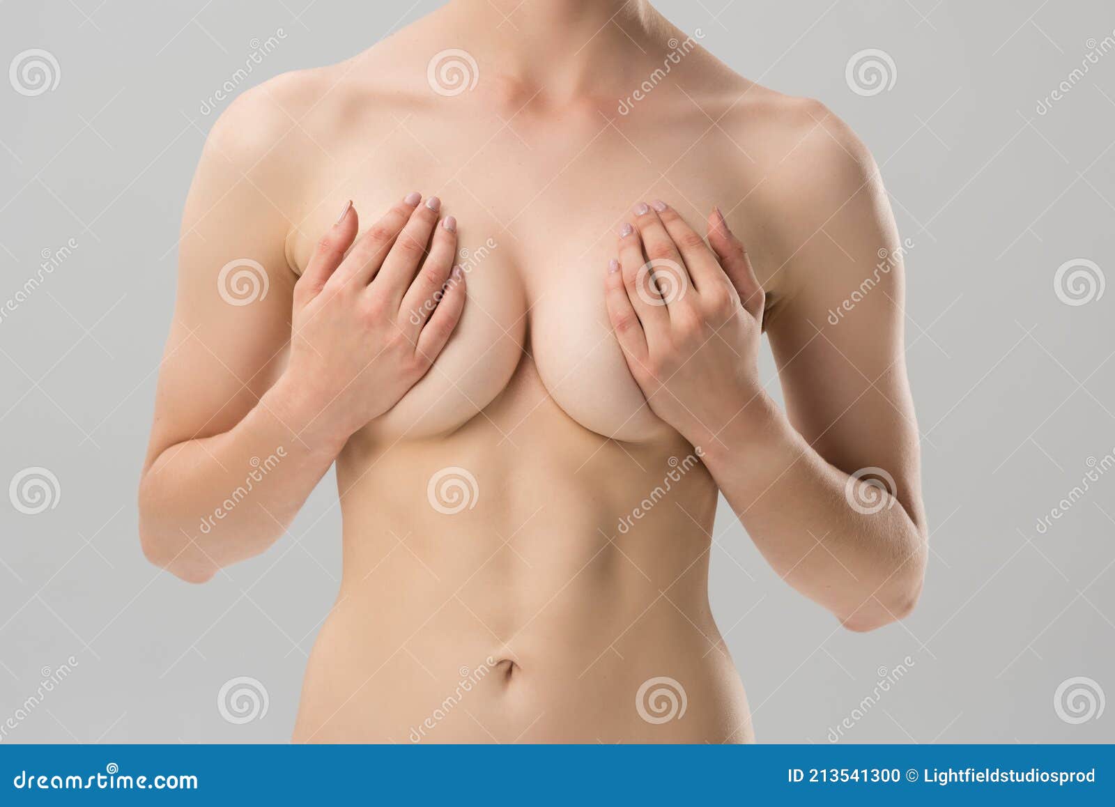 Partial View of Naked Girl Covering Breast Isolated on Grey. Stock