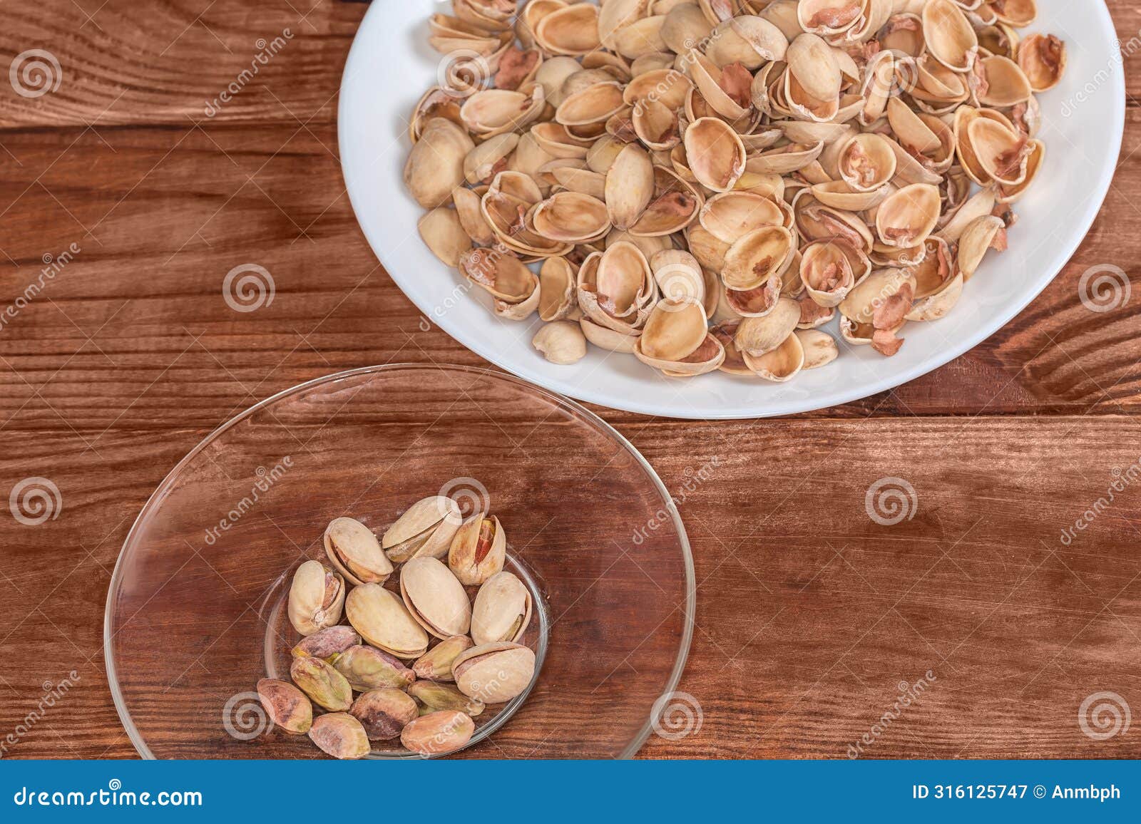 partly peeled pistachio nuts on saucer and separately empty shells