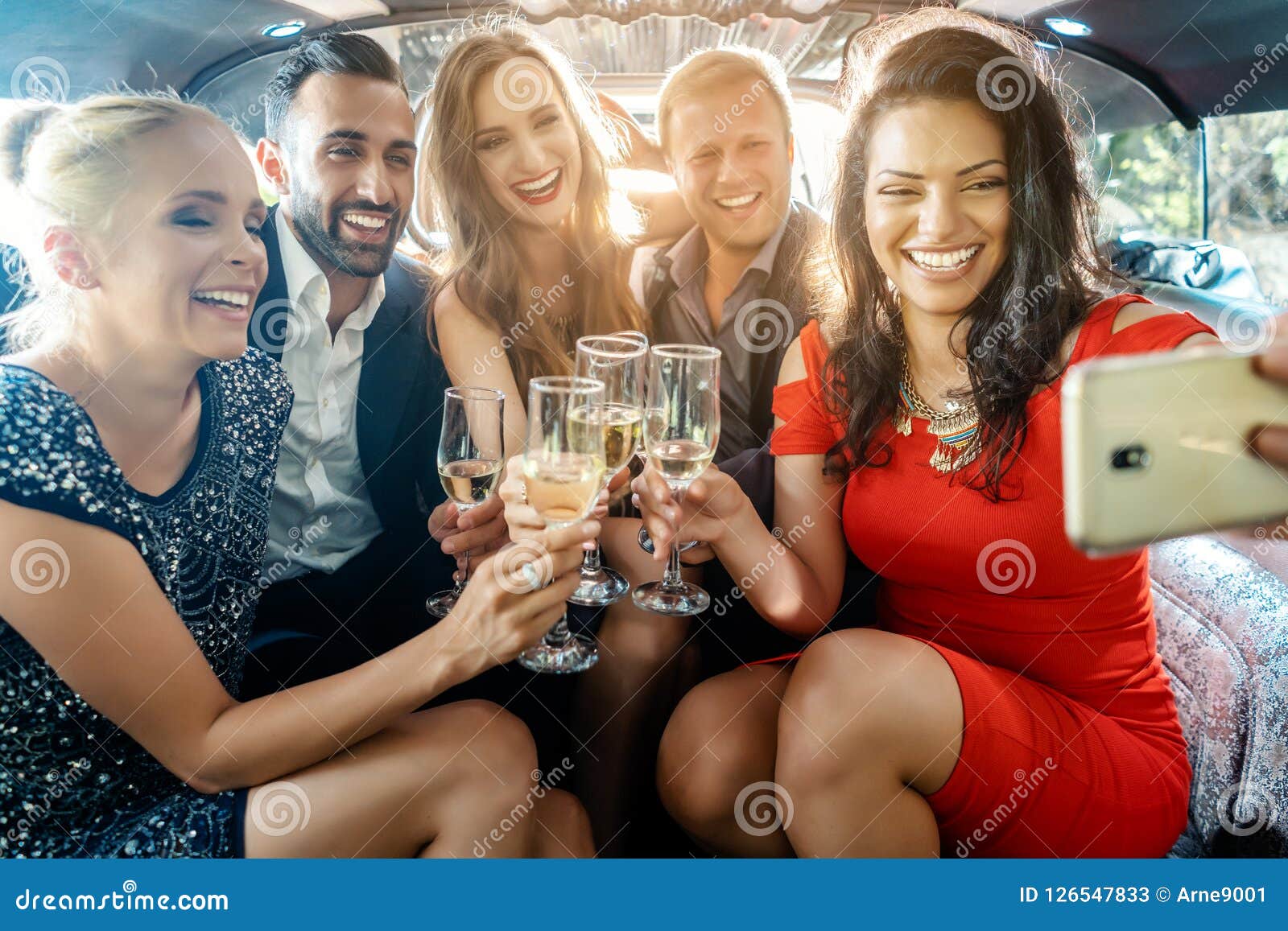 party people in a limo with drinks taking a selfie with phone