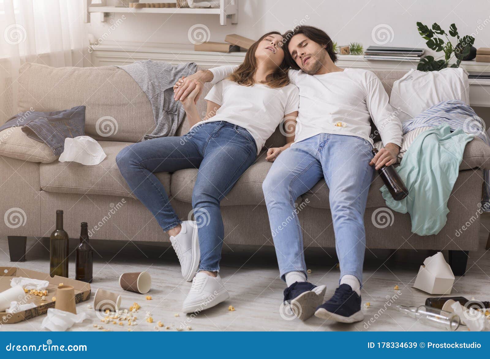 After Party Young Couple Sleeping Drunk On Couch In Messy Room Stock