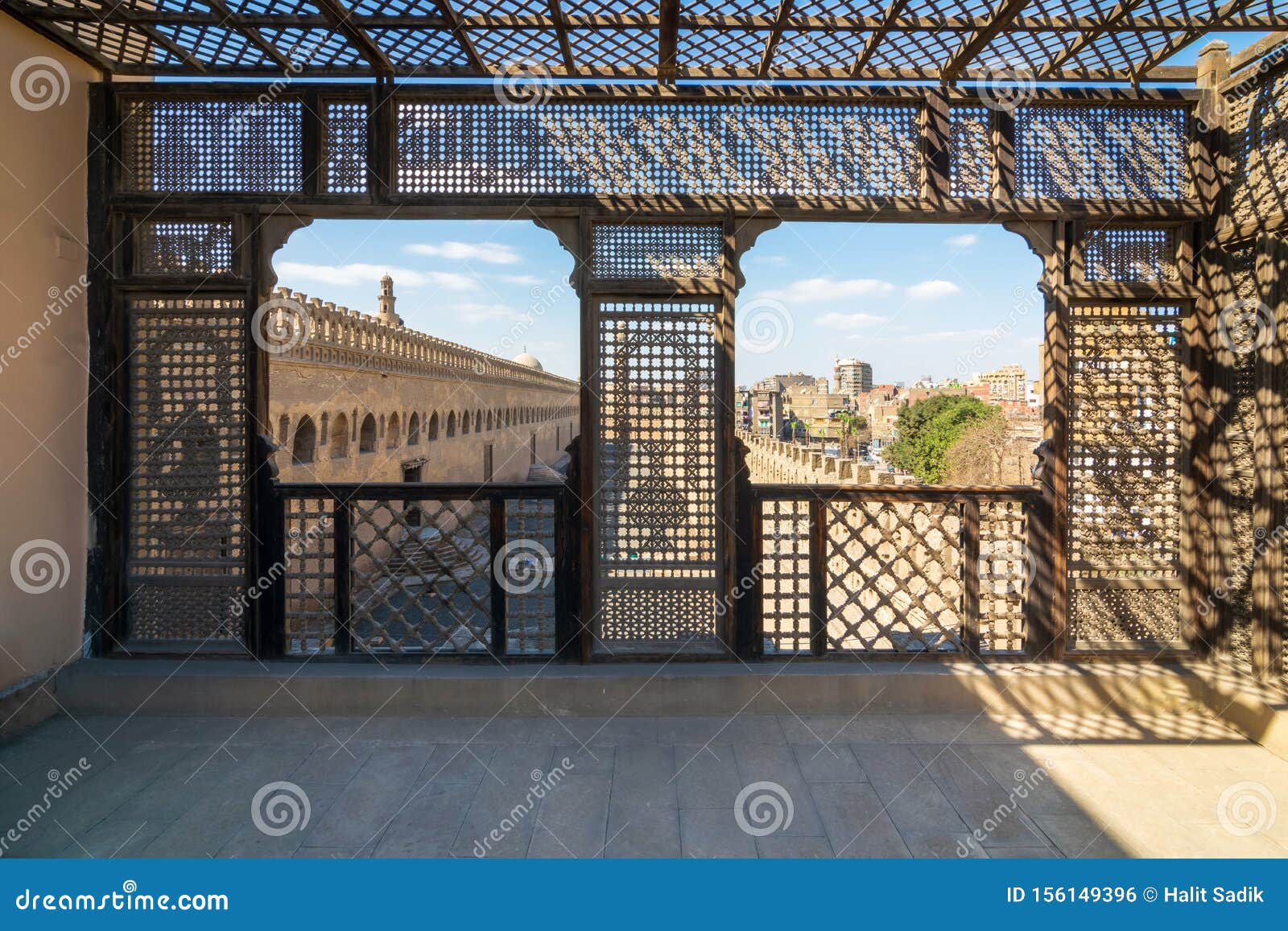 passage surrounding the mosque of ibn tulun framed by wooden window, mashrabiya, cairo, egypt