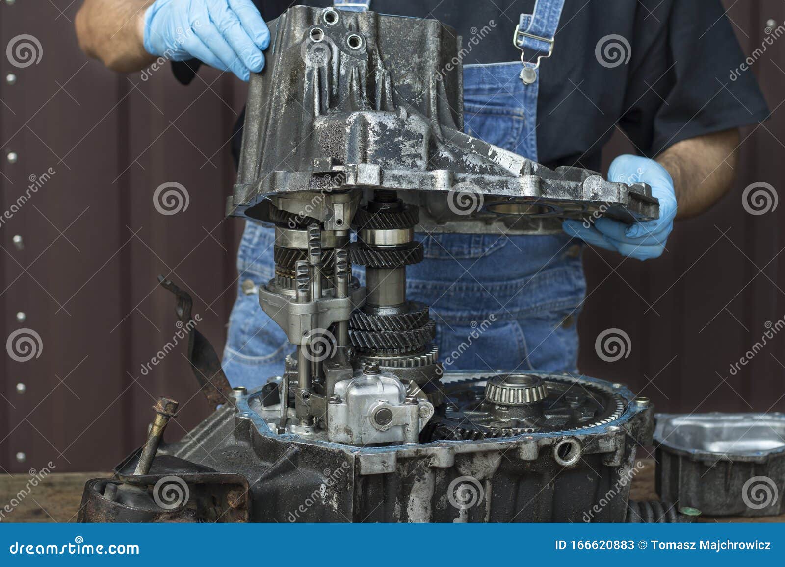 The Passenger Car Gearbox is on the Table. the Mechanic`s Hands Remove the Casing Stock Image