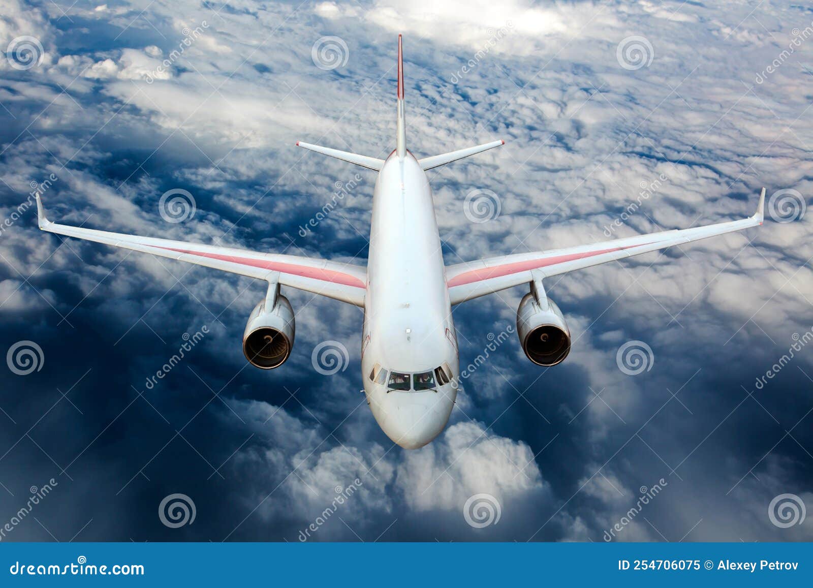 Passenger Plane Fly High in the Sky Above the Clouds. Front View Stock