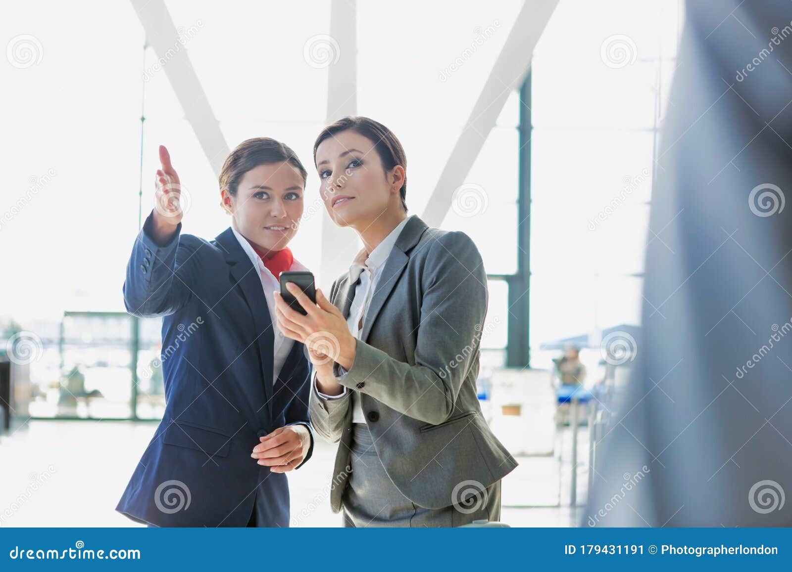 passenger service agent assisting and giving directions with businesswoman in airport