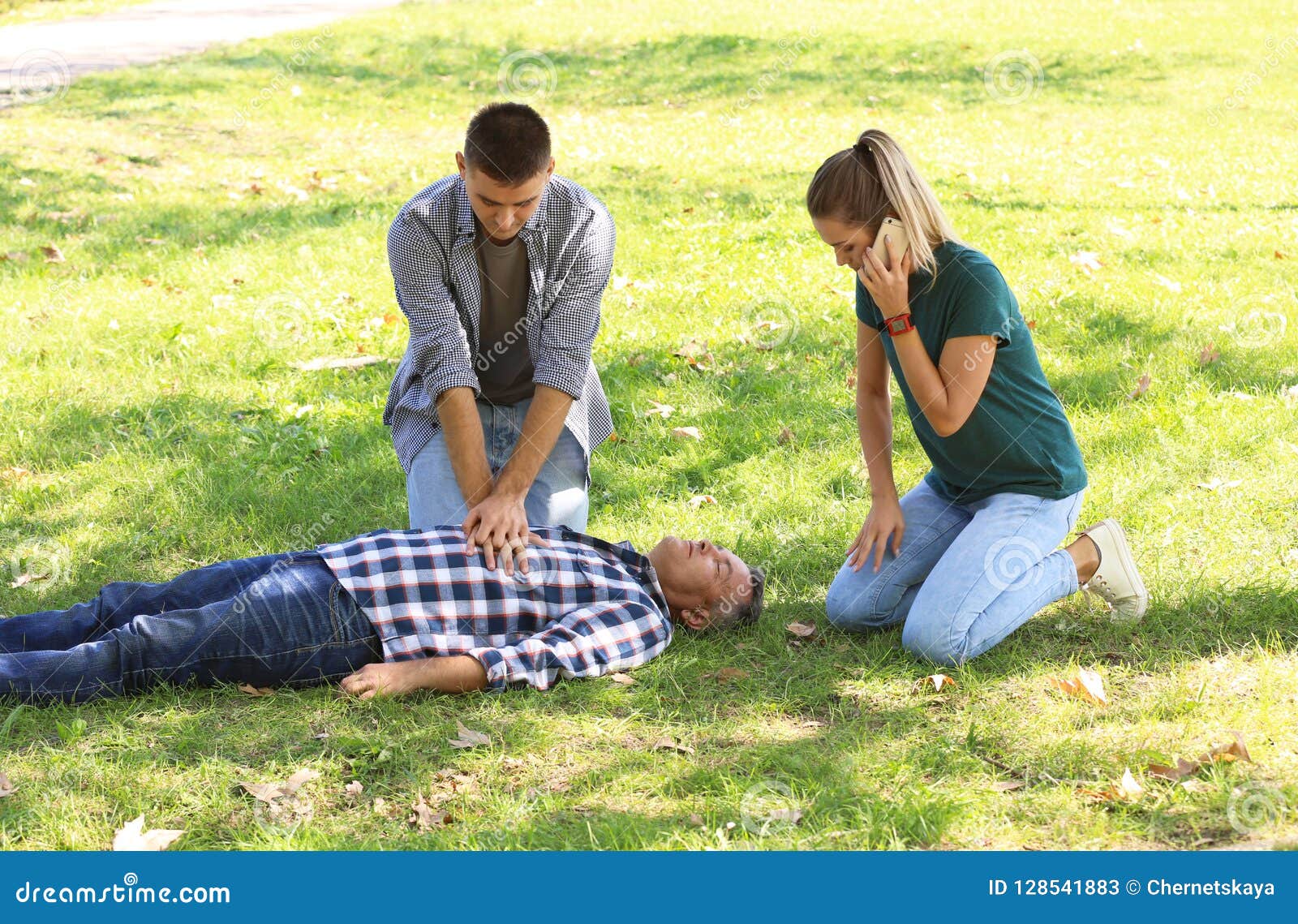 passersby helping unconscious man outdoors. first aid