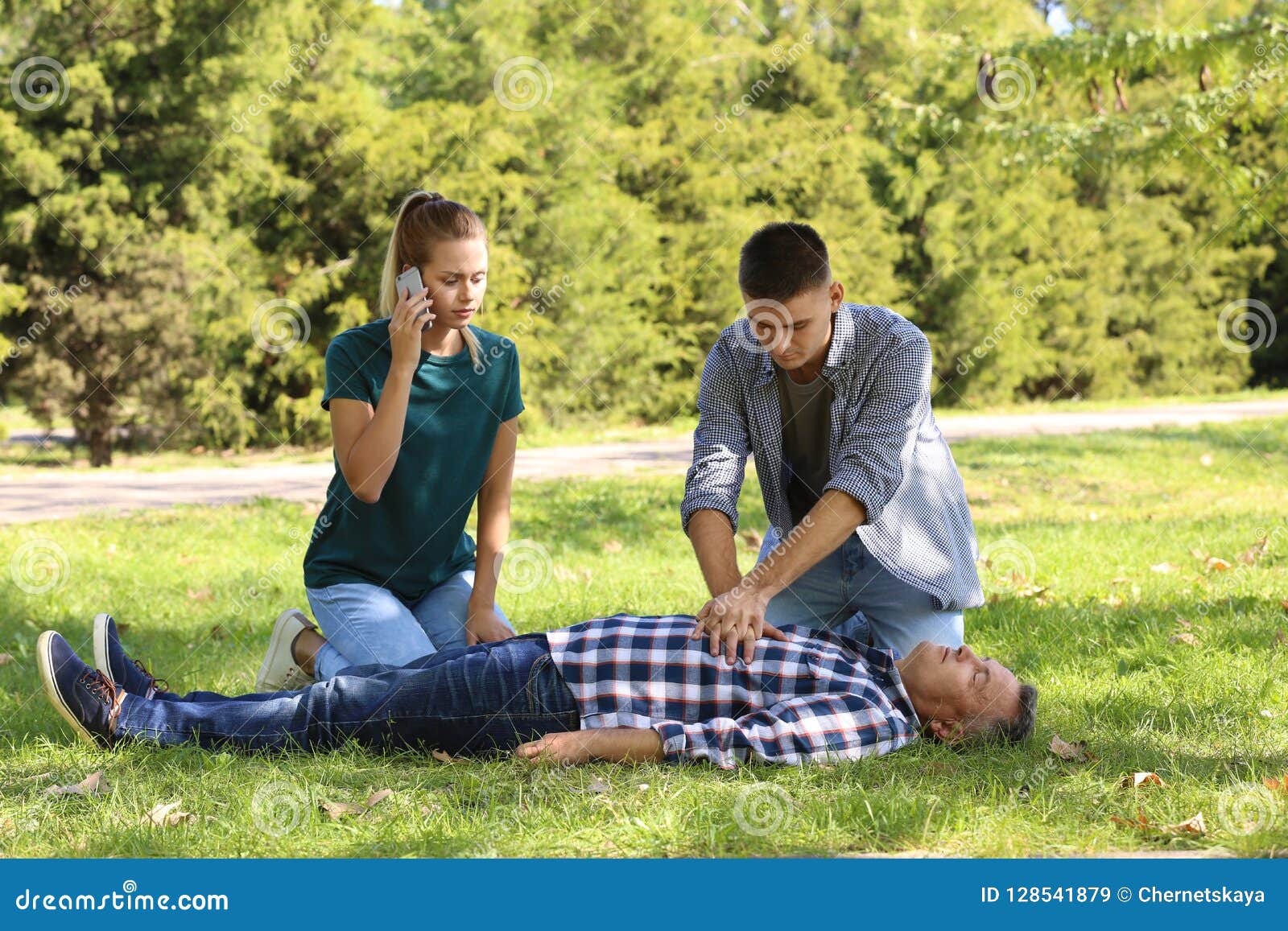 passersby helping unconscious man outdoors