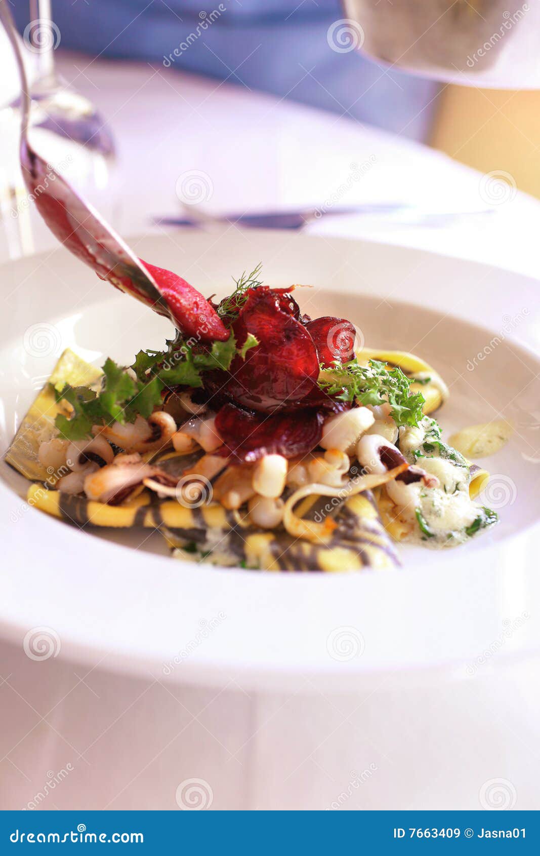 Pasta with cuttlefish,curd and salad on plate