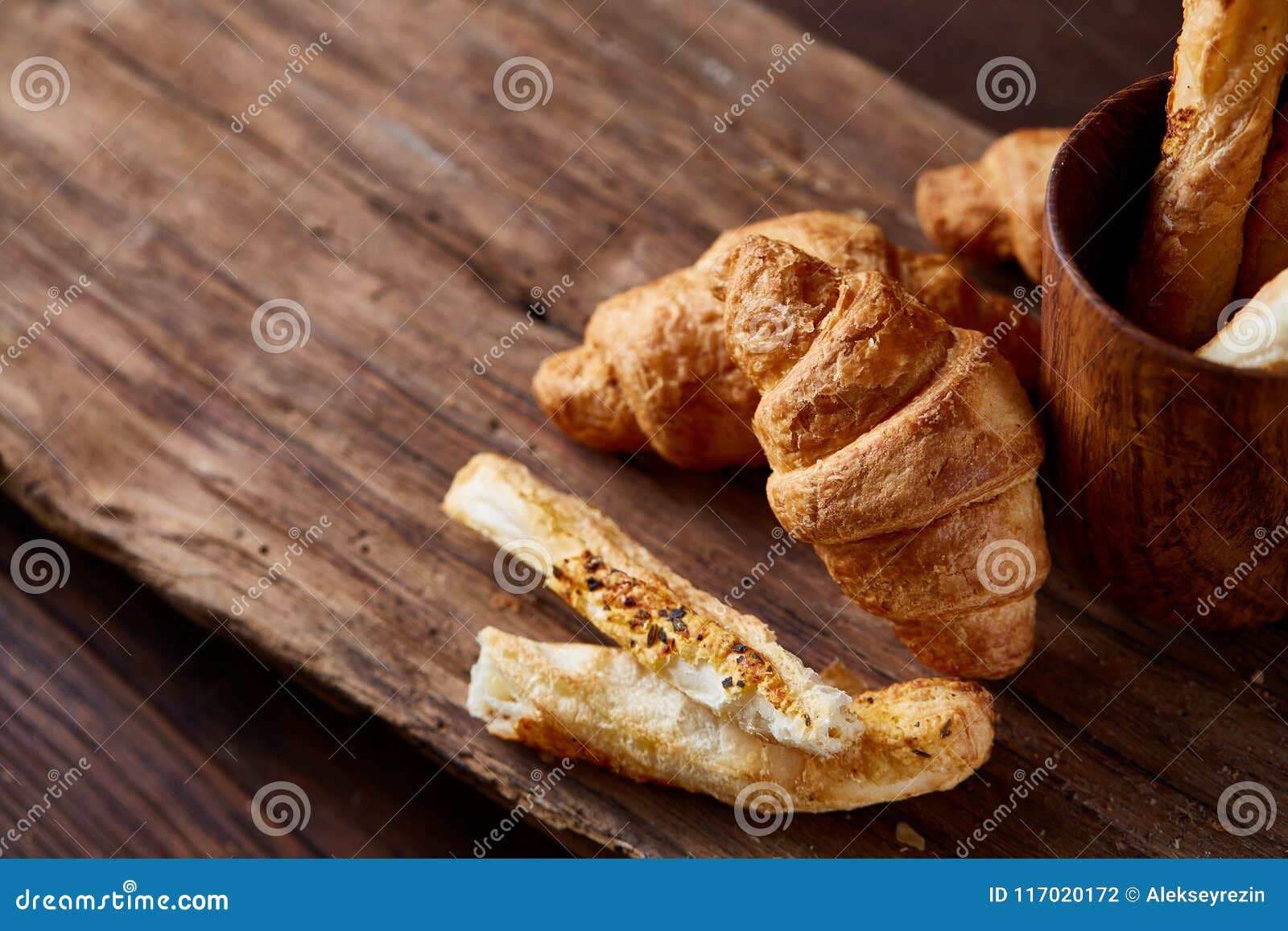 Pastas de hojaldre en la tabla de madera oscura, primer, foco selectivo, contraluz Breadsticks recientemente cocidos deliciosos y croissats hechos en casa en fondo rústico Molleja deliciosa Aún vida rural Concepto del alimento Fondo del desayuno