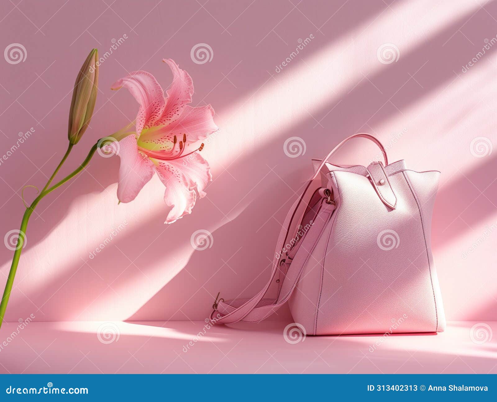 pastel pink handbag with blooming lily in soft sunlight and shadows.