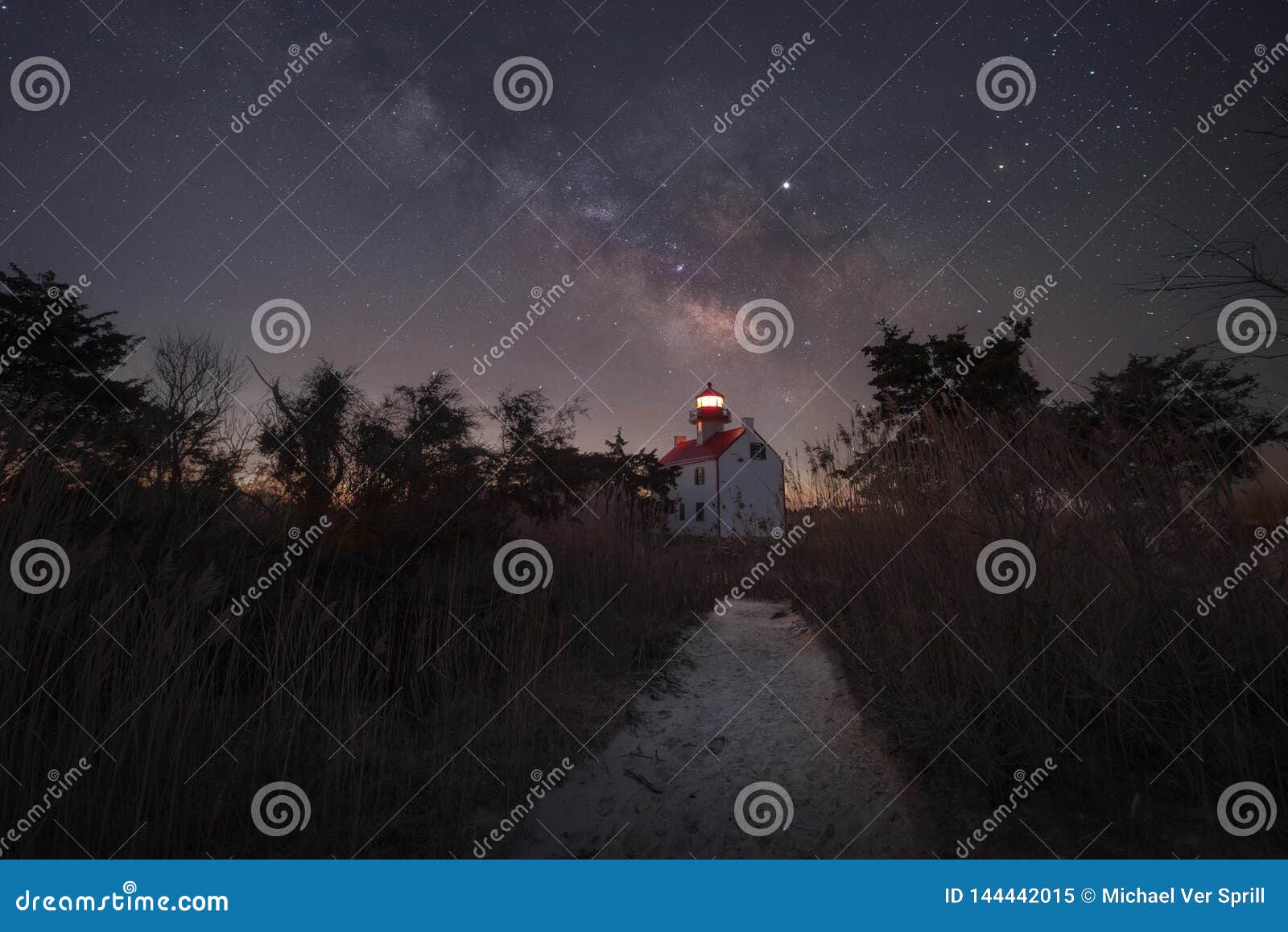 path leading towards a lighthouse at night