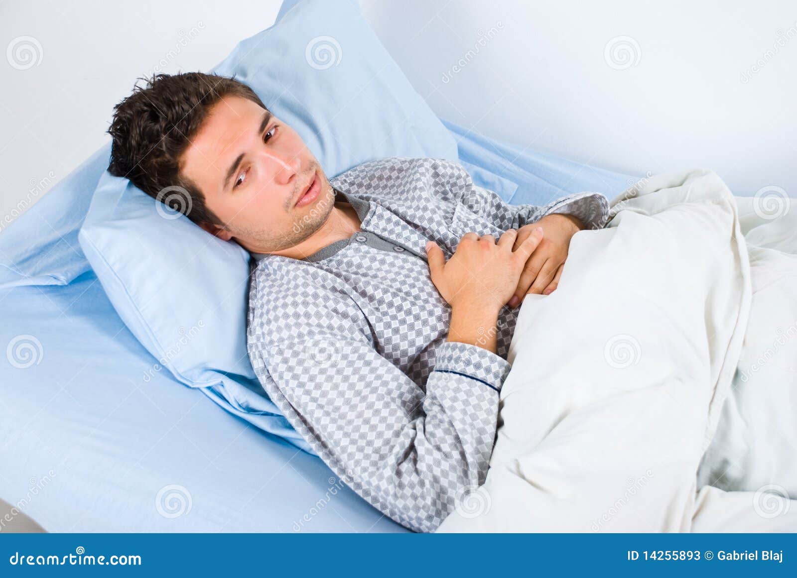 Patient man lying on bed in hospital having pain and looking away,same 