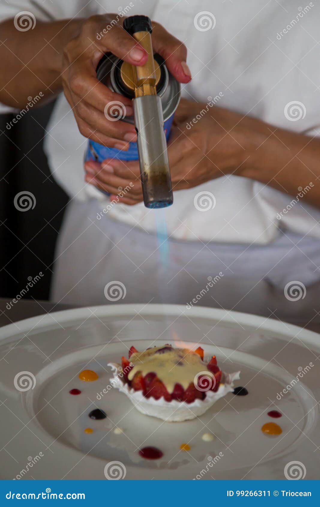patissier or chef burning creme brulee
