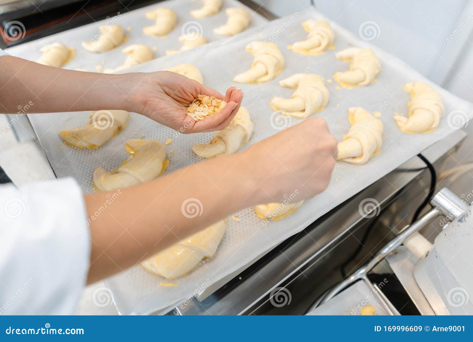 patissier in her bakery putting croissant dough pieces on a tray