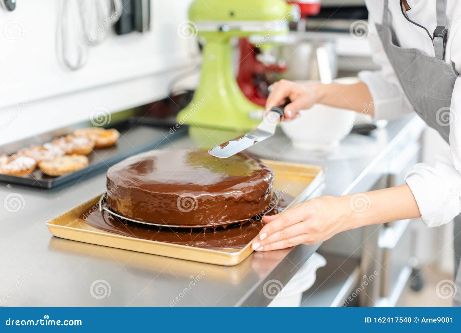 patissier pouring liquid chocolate on a cake