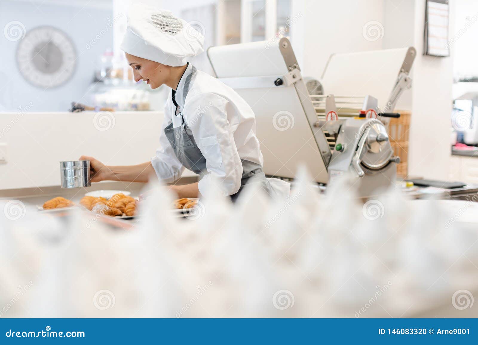 patissier in her bakery shop with lots of meringue