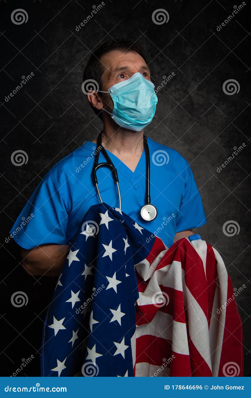 Patriotic Doctor Looking for Hope, Wearing Blue Scrubs with Face Mask and  Holding the American Flag Stock Photo - Image of american, duty: 178646696