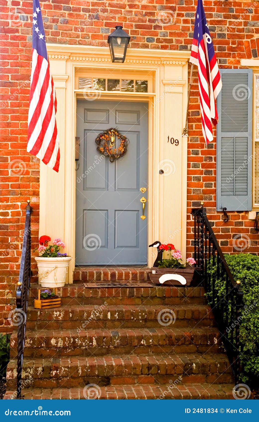 Patriotische Tür - Vertikale. Vorderer Eingang und Tür zu einem alten, historischen Gebäude des roten Ziegelsteines komplett mit amerikanischen Flaggen. Chestertown, Maryland. Verwendbar für Volkstrauertag, Viertel von Juli.