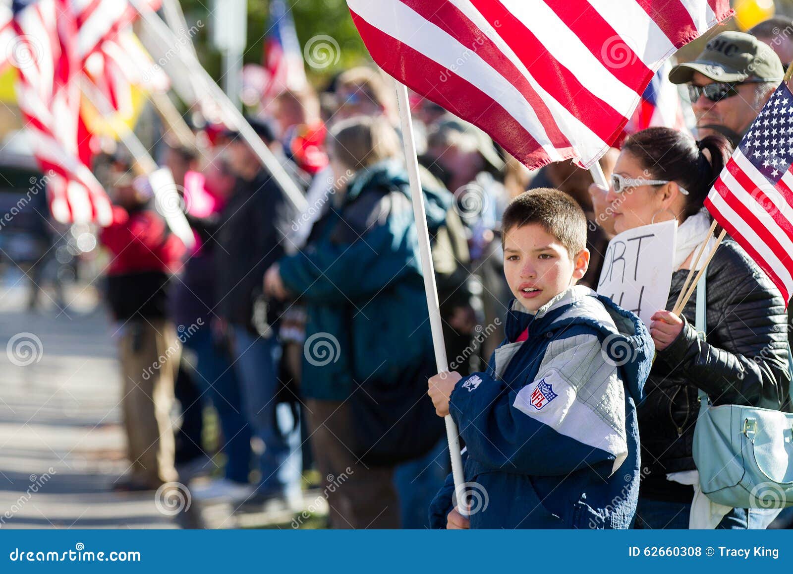 Patriottisch weinig jongen. BOISE, IDAHO/USA - 21 NOVEMBER, 2015: Kind die een Amerikaanse Vlag steunen bij het tegenprotest aan de vluchtelingensituatie in Amerika