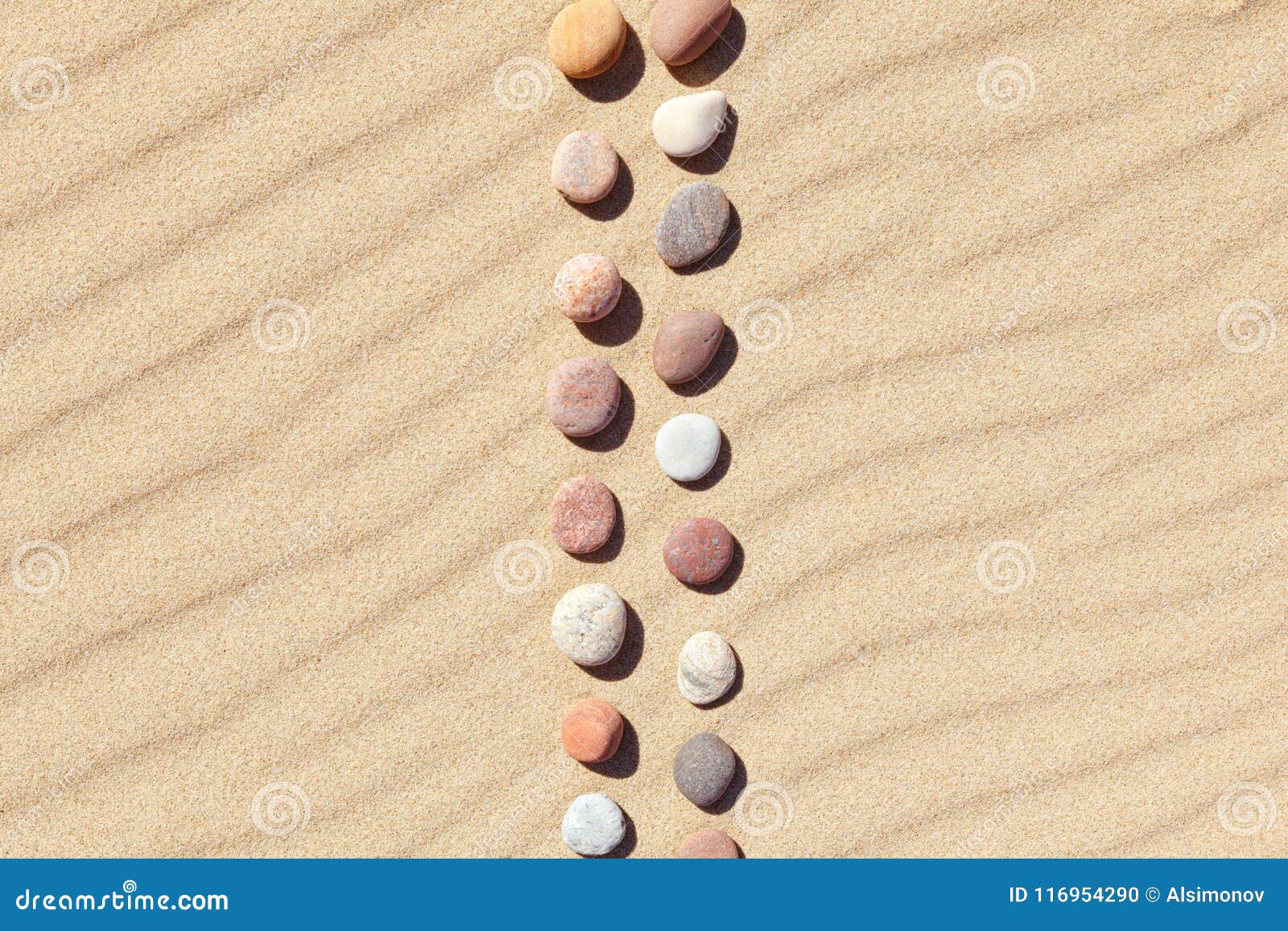 pattern of colored pebbles on clean sand. zen background, harmony and meditation concept